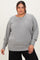 woman wearing a gray plus size sweatshirt with a relaxed fit and ribbed hem, posing with a confident expression