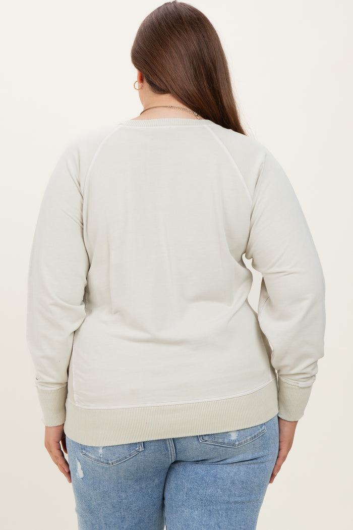 woman wearing a light beige maternity plus sweatshirt, shown from the back