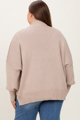 woman wearing a taupe oversized maternity sweater with a high neck and drop shoulders