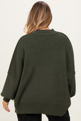 woman wearing an olive green oversized maternity sweater with wide sleeves, seen from the back