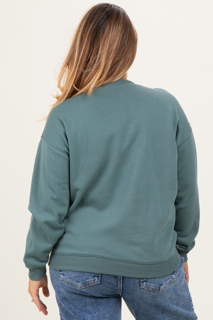 woman wearing a green maternity plus crewneck sweatshirt, viewed from the back, with loose fit and ribbed hem