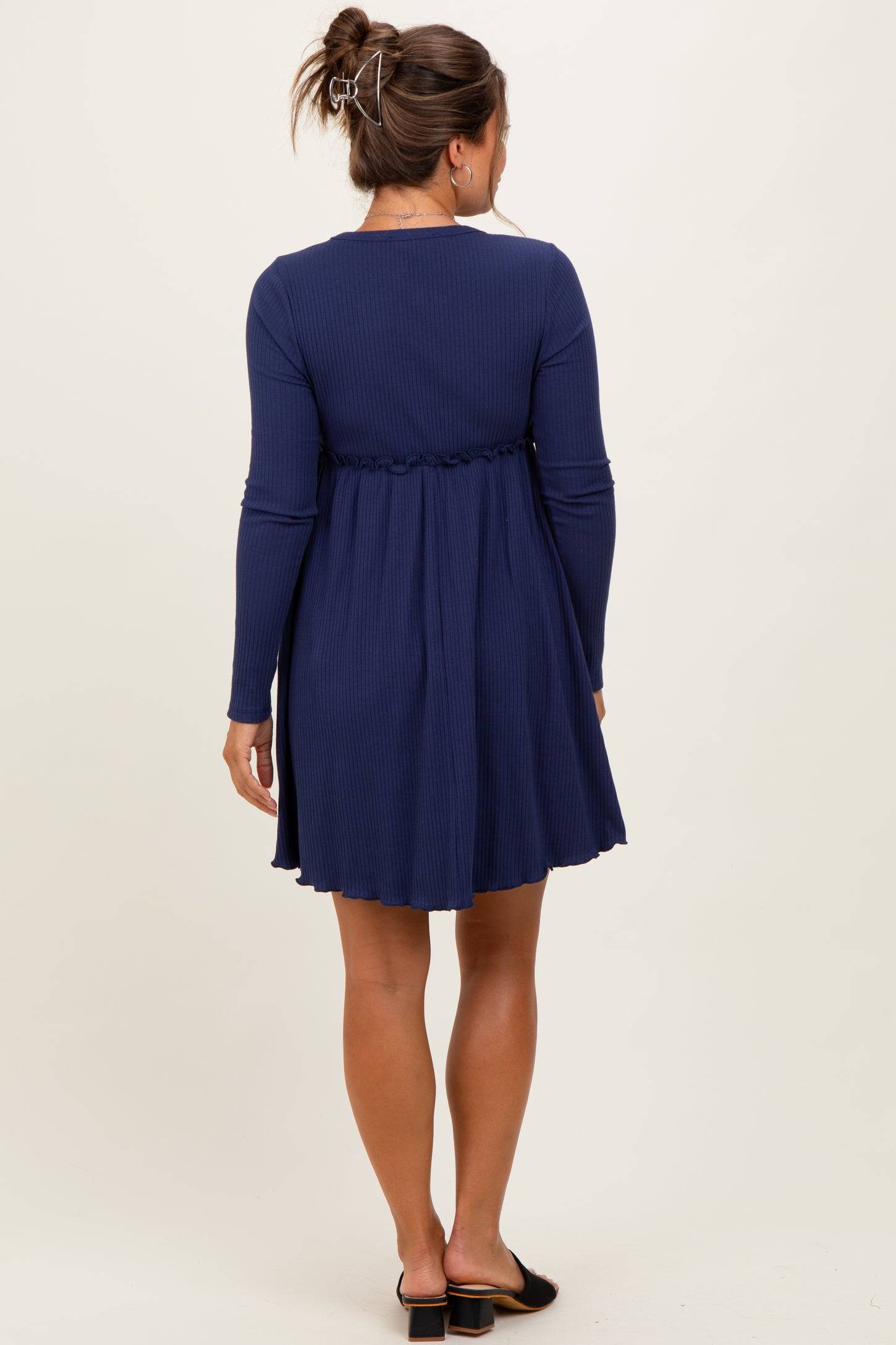 woman wearing a navy long sleeve maternity dress with a gathered waistline, shown from the back