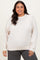 woman wearing a light beige plus size sweatshirt with long sleeves and a relaxed fit, paired with dark gray bottoms
