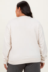 woman wearing a light beige plus size crewneck sweatshirt, seen from the back, with a relaxed fit and long sleeves