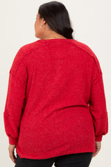 plus size woman wearing a red oversized knit sweater with drop shoulders and long sleeves