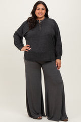 woman wearing a dark gray loose-fitting sweater with buttons and matching wide-leg pants