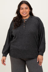 woman wearing a dark gray ribbed long sleeve top with buttons and relaxed fit, paired with gray pants