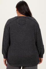 plus size woman wearing a dark gray oversized knit sweater, viewed from the back