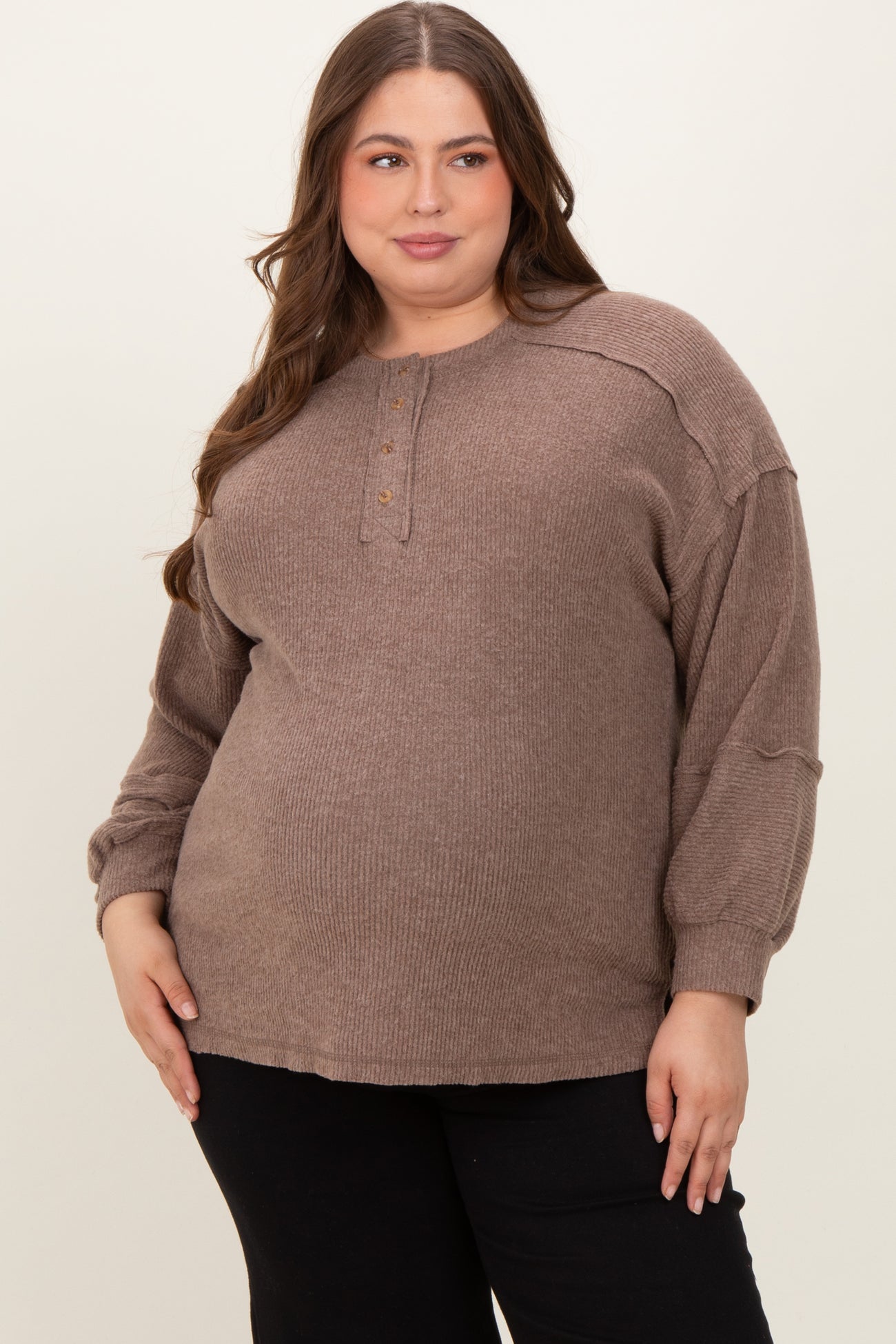woman wearing a taupe maternity plus long sleeve sweater with buttons and relaxed fit, showing her baby bump