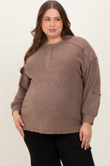 woman wearing a taupe maternity plus long sleeve sweater with buttons and relaxed fit, showing her baby bump