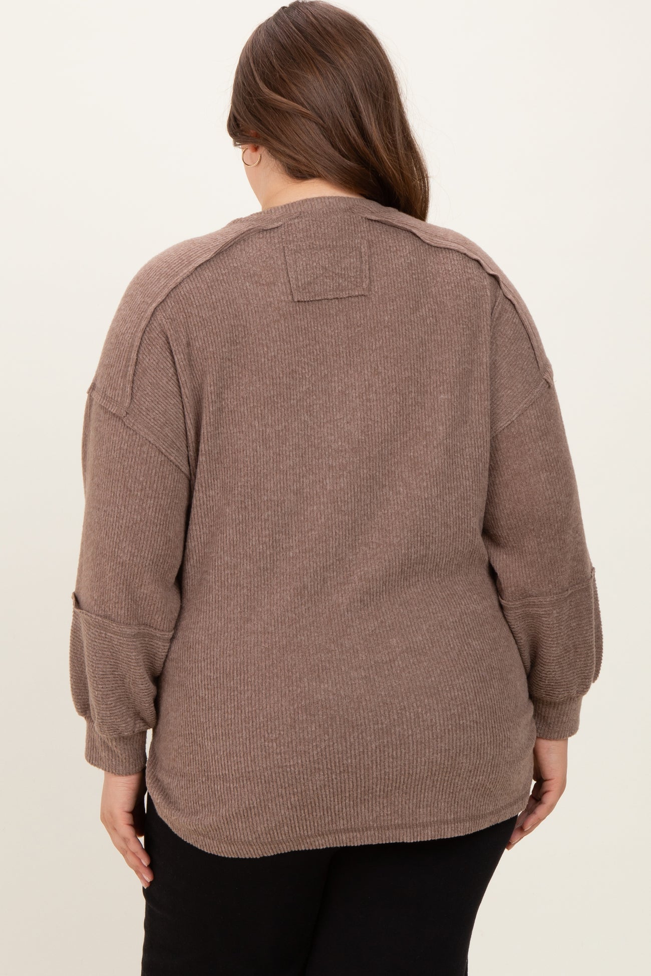 woman wearing a taupe oversized maternity sweater with a relaxed fit and ribbed texture, viewed from the back