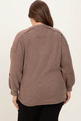 woman wearing a taupe oversized maternity sweater with a relaxed fit and ribbed texture, viewed from the back