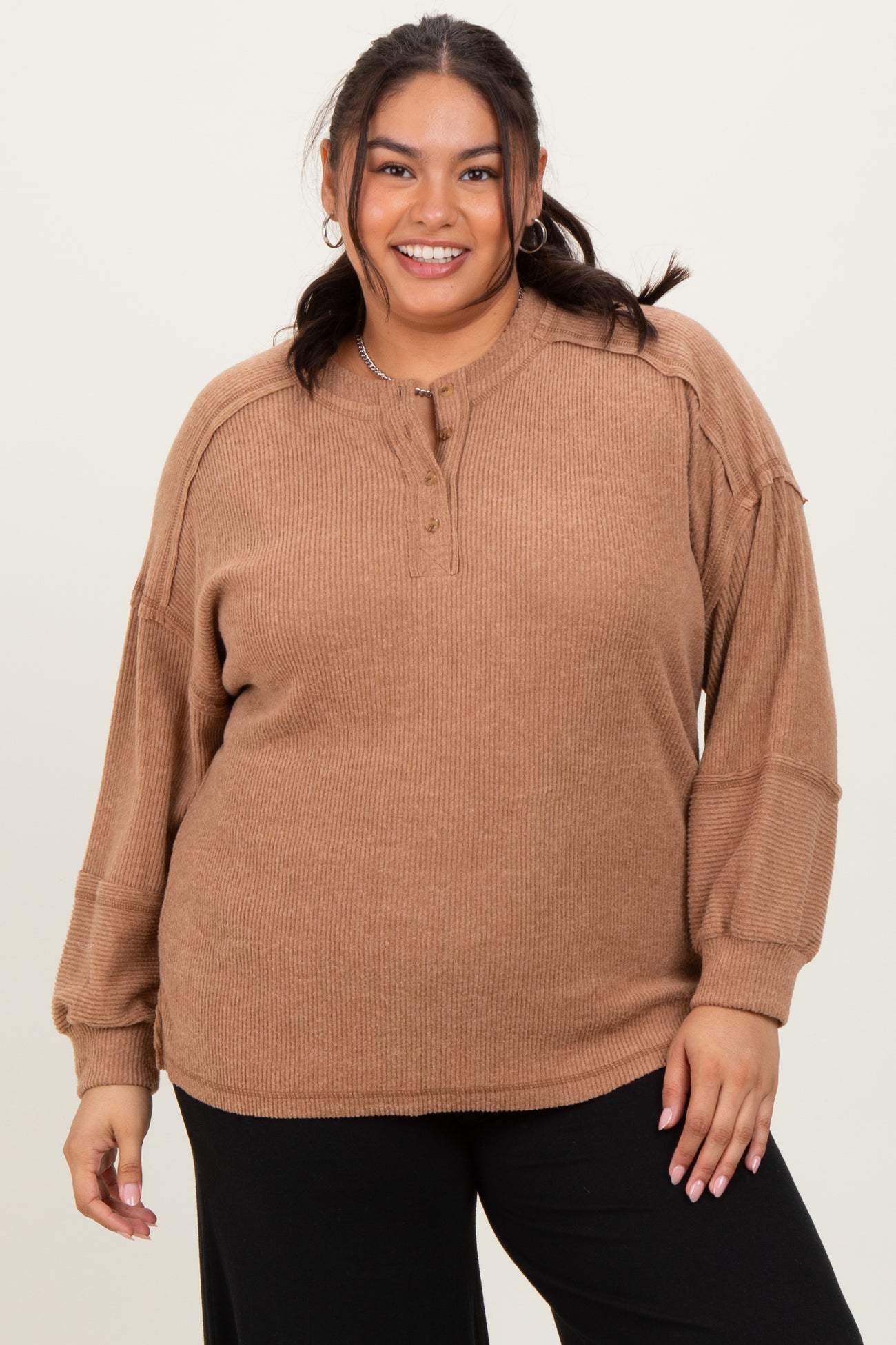woman wearing a brown ribbed plus size pullover with a henley neckline and relaxed fit