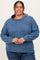 woman wearing a blue ribbed long sleeve plus size sweater and smiling at the camera