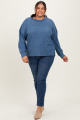 woman wearing a light blue oversized ribbed sweater and dark blue skinny jeans, walking towards the camera