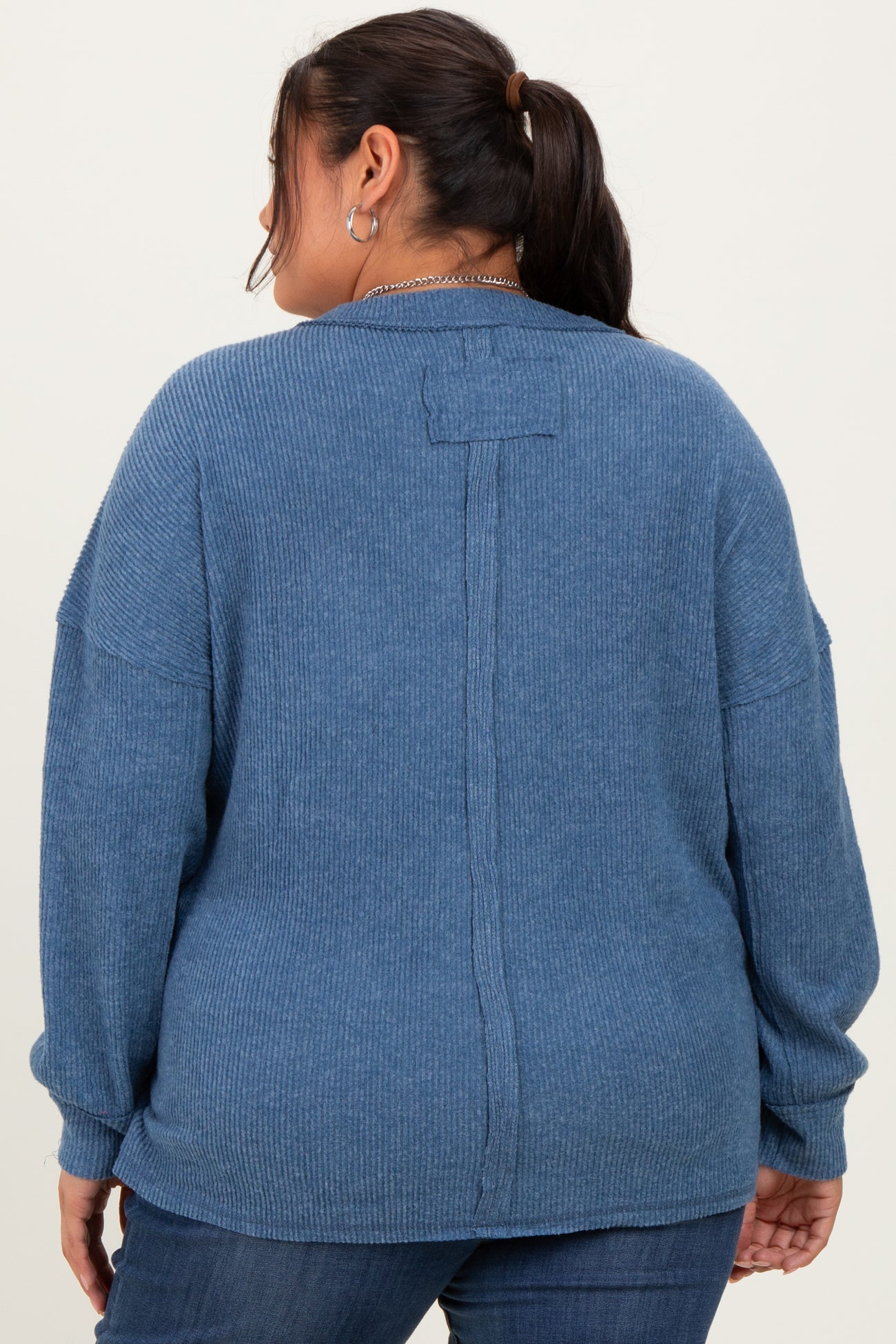 woman wearing a cozy blue plus size ribbed sweater with a relaxed fit and back seam detail