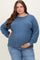woman wearing a blue ribbed maternity sweater and holding her baby bump
