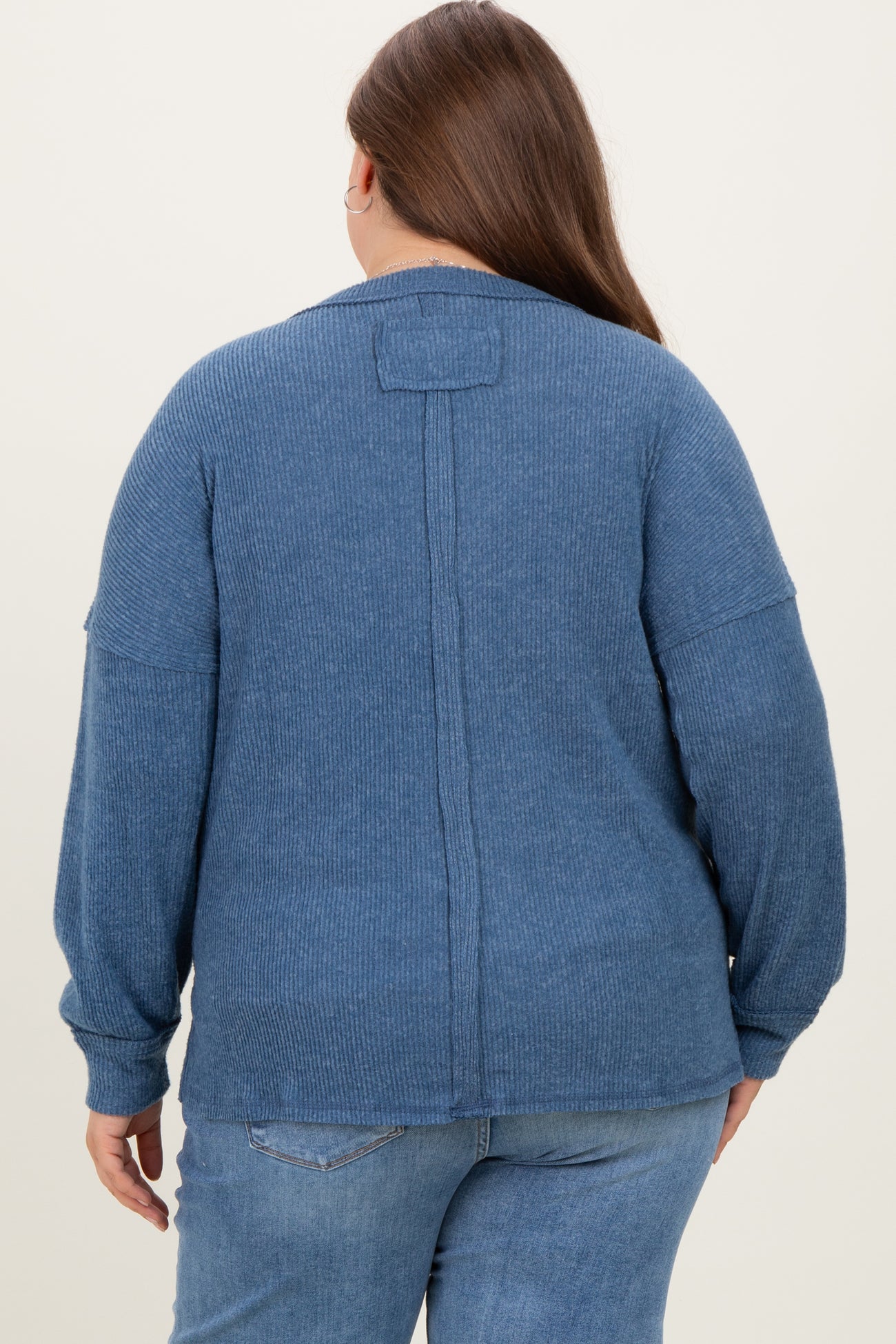 woman wearing a dark blue maternity plus sweater with a relaxed fit and back seam detail