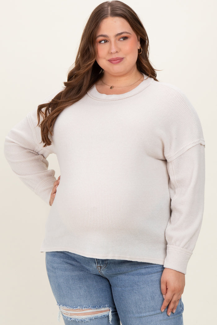 woman wearing a light beige ribbed maternity plus sweater with a relaxed fit and a visible baby bump