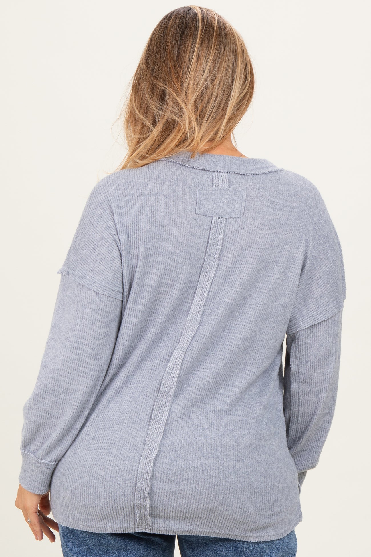 woman wearing a light gray ribbed maternity sweater featuring a back seam detail