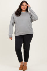 woman wearing a gray oversized sweatshirt paired with black cropped jeans and brown slip-on shoes