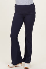 woman wearing navy blue flared yoga pants with a wide waistband and white sneakers