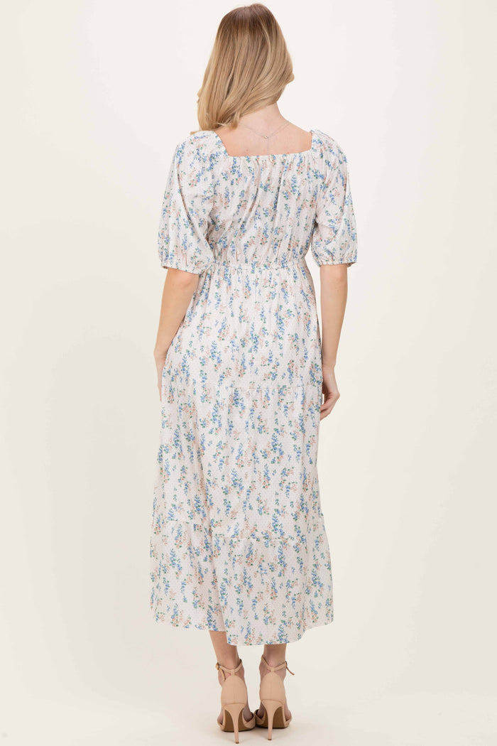 woman wearing a floral print midi dress with puff sleeves and a square neckline, shown from the back