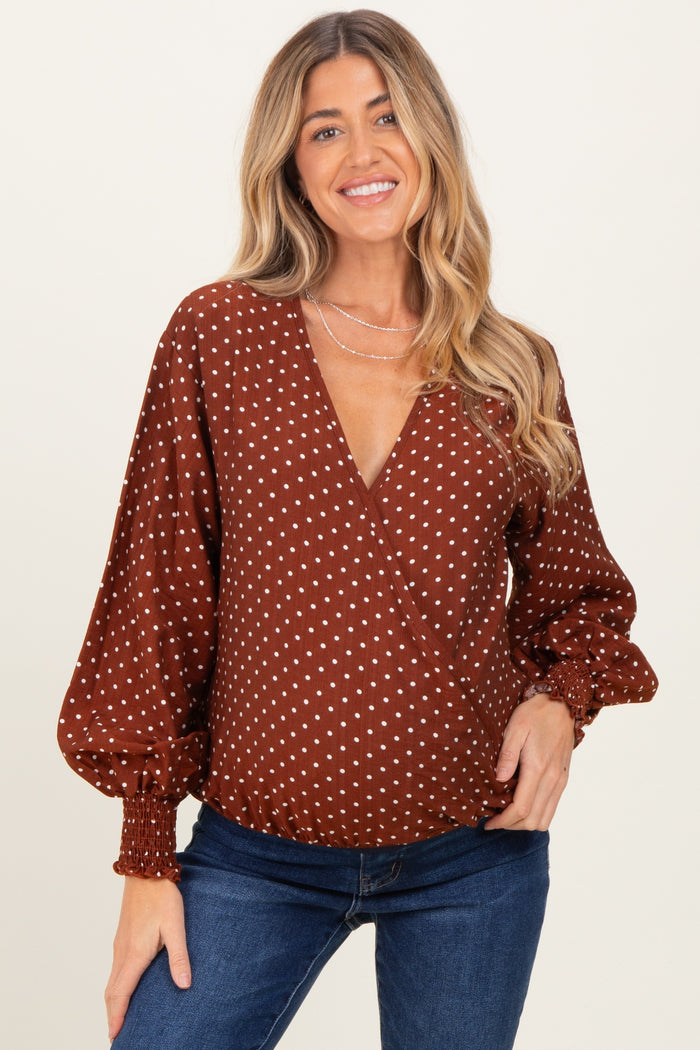 woman wearing a brown polka dot wrap maternity top with balloon sleeves and a v-neckline