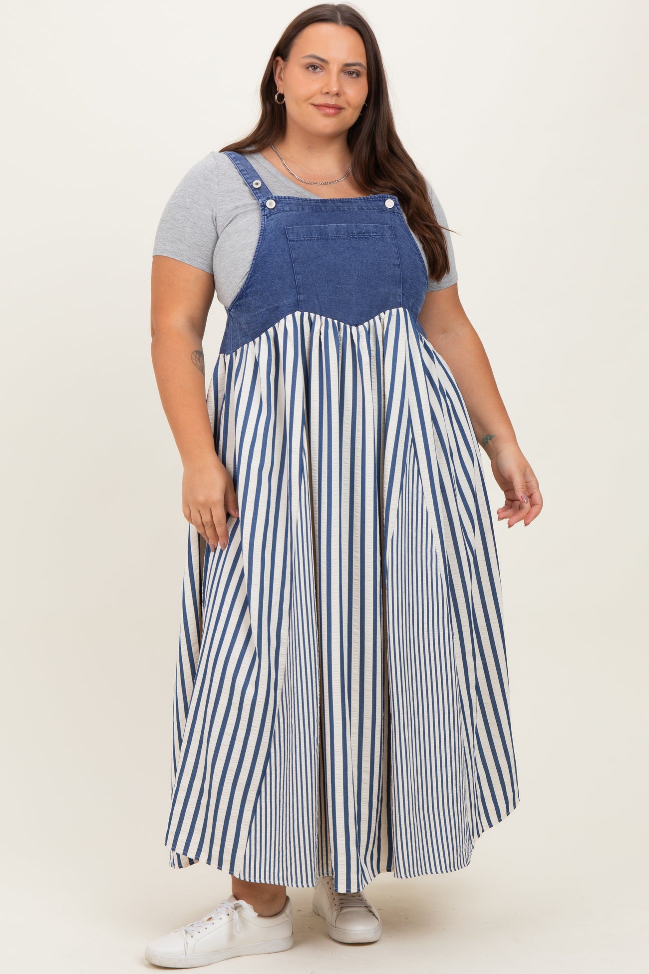 woman wearing a blue denim and striped long maxi dress with a fitted bodice and relaxed skirt