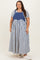 woman wearing a denim and striped plus size midi dress styled with a fitted gray t-shirt underneath