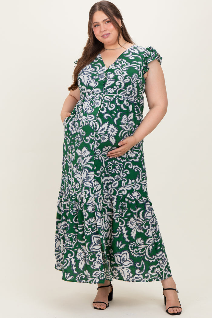 woman wearing a green floral maternity plus maxi dress with ruffled sleeves and a baby bump