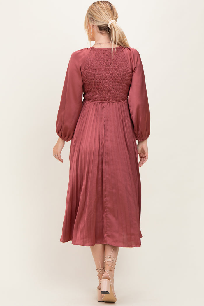 woman wearing a wine-colored midi dress with smocked bodice and long sleeves, shown from the back