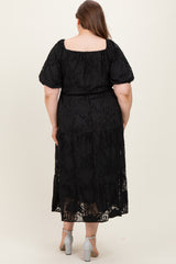 maternity plus model wearing a black floral lace maxi dress with short puff sleeves and a tiered skirt