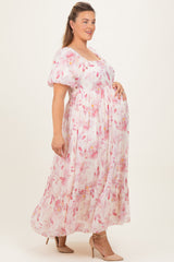 woman wearing a pink floral maternity maxi dress with puff sleeves and a visible baby bump