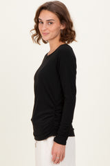 woman wearing a black long sleeve ribbed top with side ruching and a round neckline