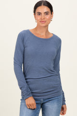 woman wearing a blue long sleeve ribbed top with a relaxed fit and scoop neckline, paired with jeans