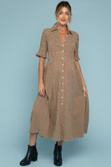 woman wearing a brown and cream checked maternity midi dress with short sleeves and button details