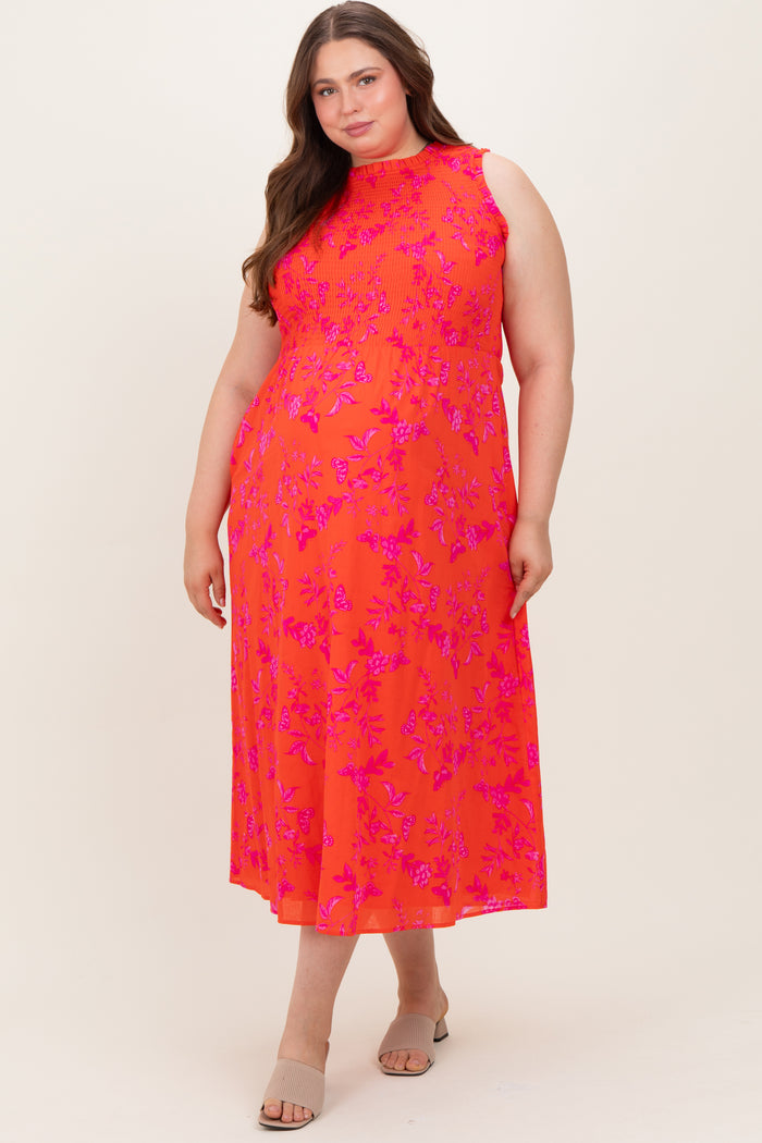 woman wearing a bright pink floral maxi maternity dress with sleeveless design and a fitted bodice