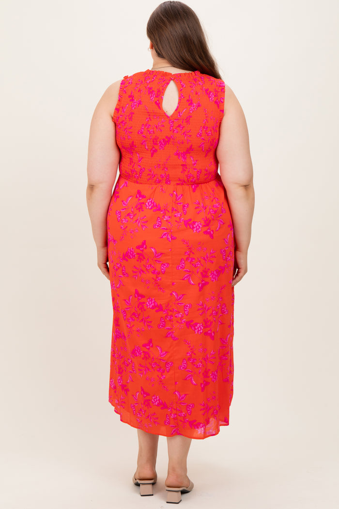 woman wearing a coral pink maternity plus dress with a floral pattern and keyhole back detail, shown from the back