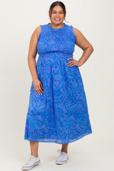 woman wearing a blue floral print plus size maxi dress with a cinched waist and relaxed fit, styled with white sneakers