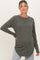 woman wearing a dark green long sleeve maternity top with a ribbed texture and a visible baby bump