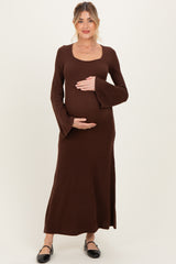 woman wearing a brown long sleeve ribbed maternity dress and cradling her baby bump