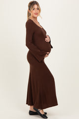 woman wearing a brown long sleeve maternity dress with flared sleeves and a visible baby bump