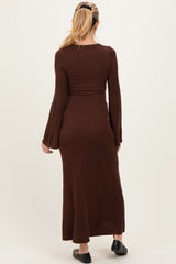 woman wearing a brown long sleeve maternity dress with a fitted silhouette and flared sleeves