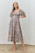 woman wearing a lilac floral midi dress with puff sleeves and a square neckline, standing in a casual pose