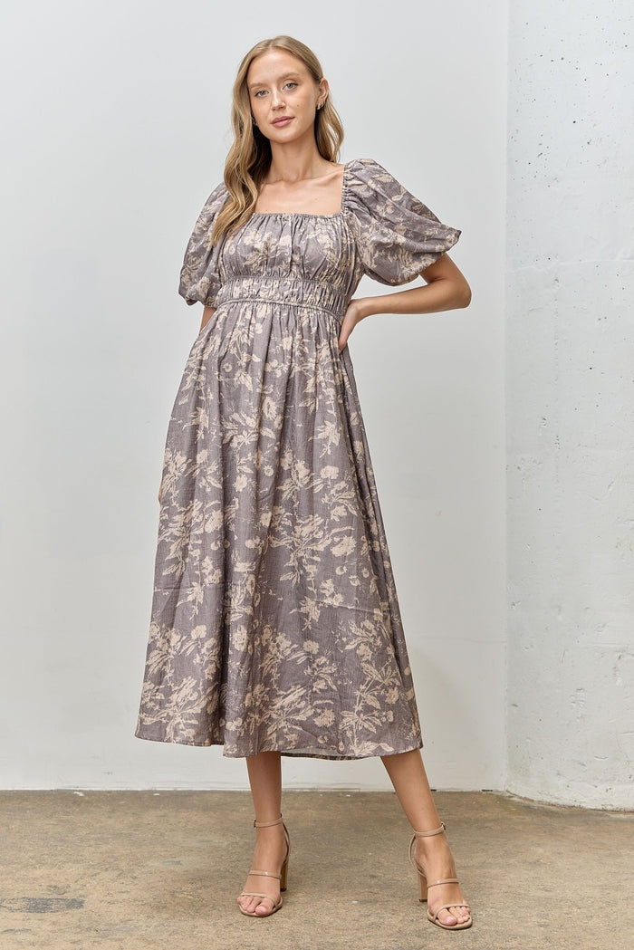 woman wearing a lilac floral midi dress with puff sleeves and a square neckline, standing in a casual pose