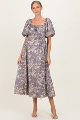 woman wearing a lavender floral maternity dress with puff sleeves and a smocked bodice