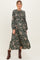 woman wearing a dark green floral print maternity dress with long sleeves and a fitted bodice showcasing her baby bump