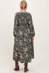 maternity wear long sleeve green floral dress with smocked back and flowing skirt, model viewed from the back
