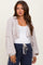 woman wearing a light taupe cropped cardigan over a white tank top and navy sweatpants, showcasing her baby bump
